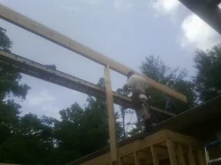 Carpenter setting a ridge beam over a new addition frame — Ice Dam Removal by Roofing Brothers in Tujunga