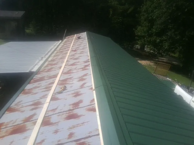 Old rusted panels beside newly installed green metal roofing — Wind Damage Roof Repair by Roofing Brothers in Tujunga
